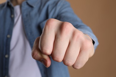 Photo of Man showing fist with space for tattoo on beige background, selective focus