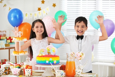 Happy children at birthday party in decorated room