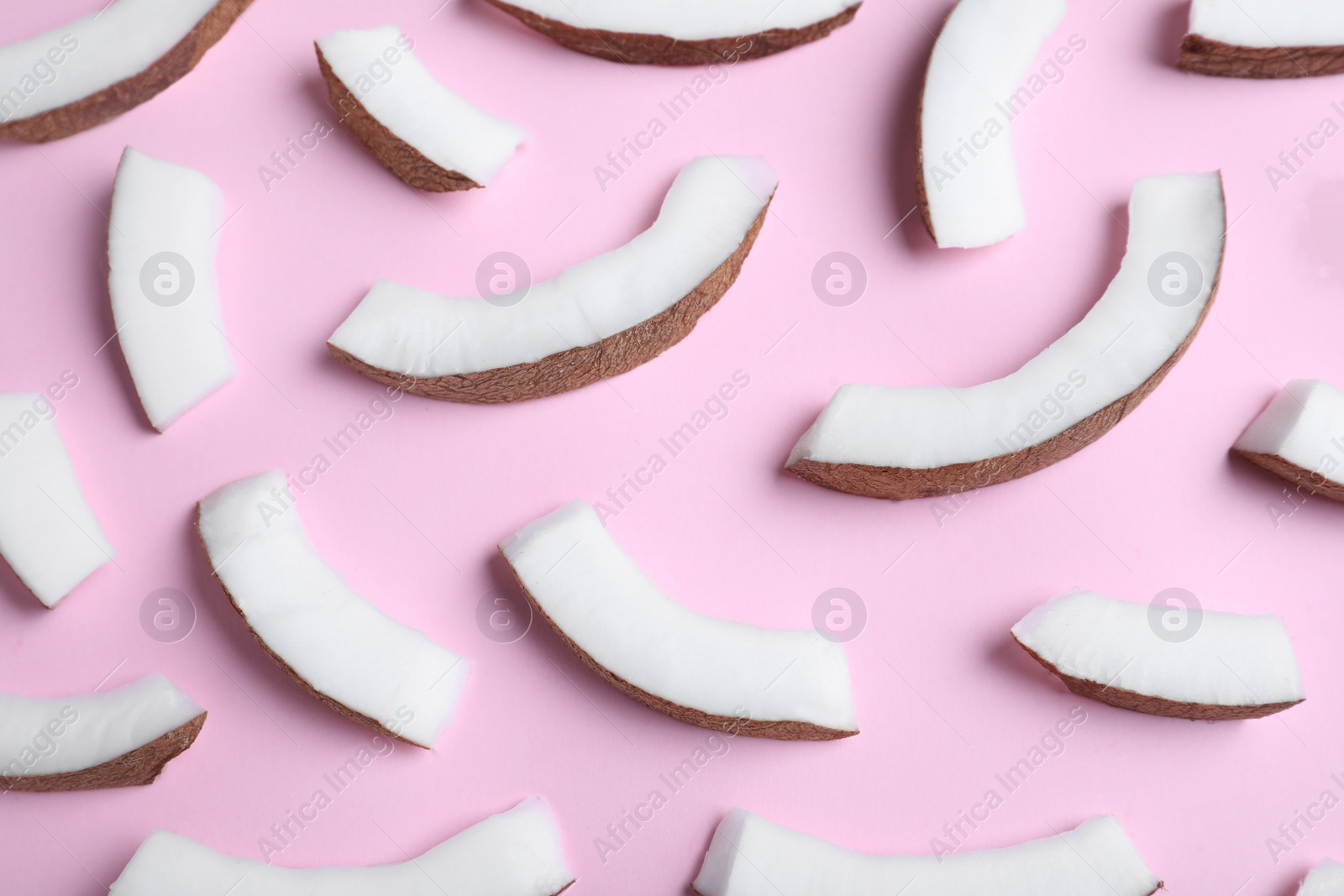 Photo of Fresh coconut pieces on pink background, above view