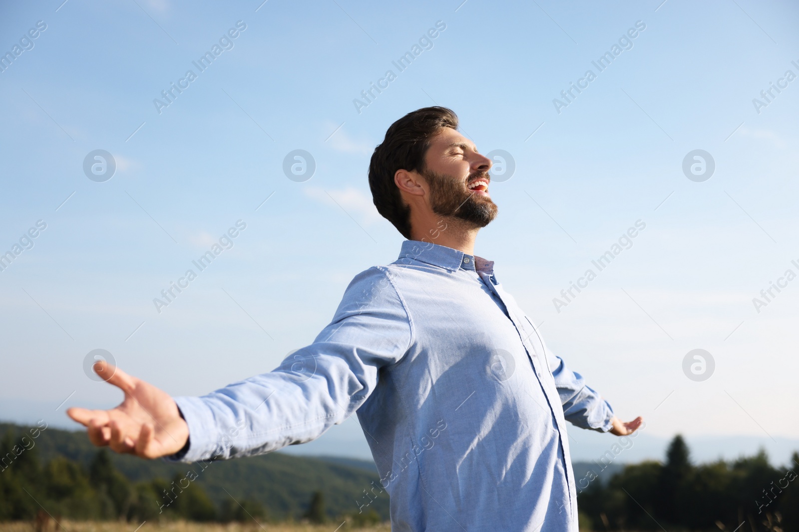 Photo of Feeling freedom. Happy man with wide open arms outdoors