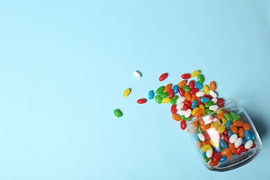 Glass jar with bright jelly candies on color background, flat lay. Space for text