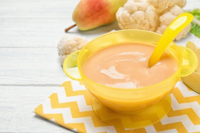 Photo of Healthy baby food and fresh ingredients on white wooden table, closeup