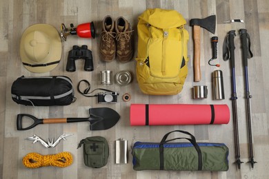 Flat lay composition with different camping equipment on wooden background. Traveler set