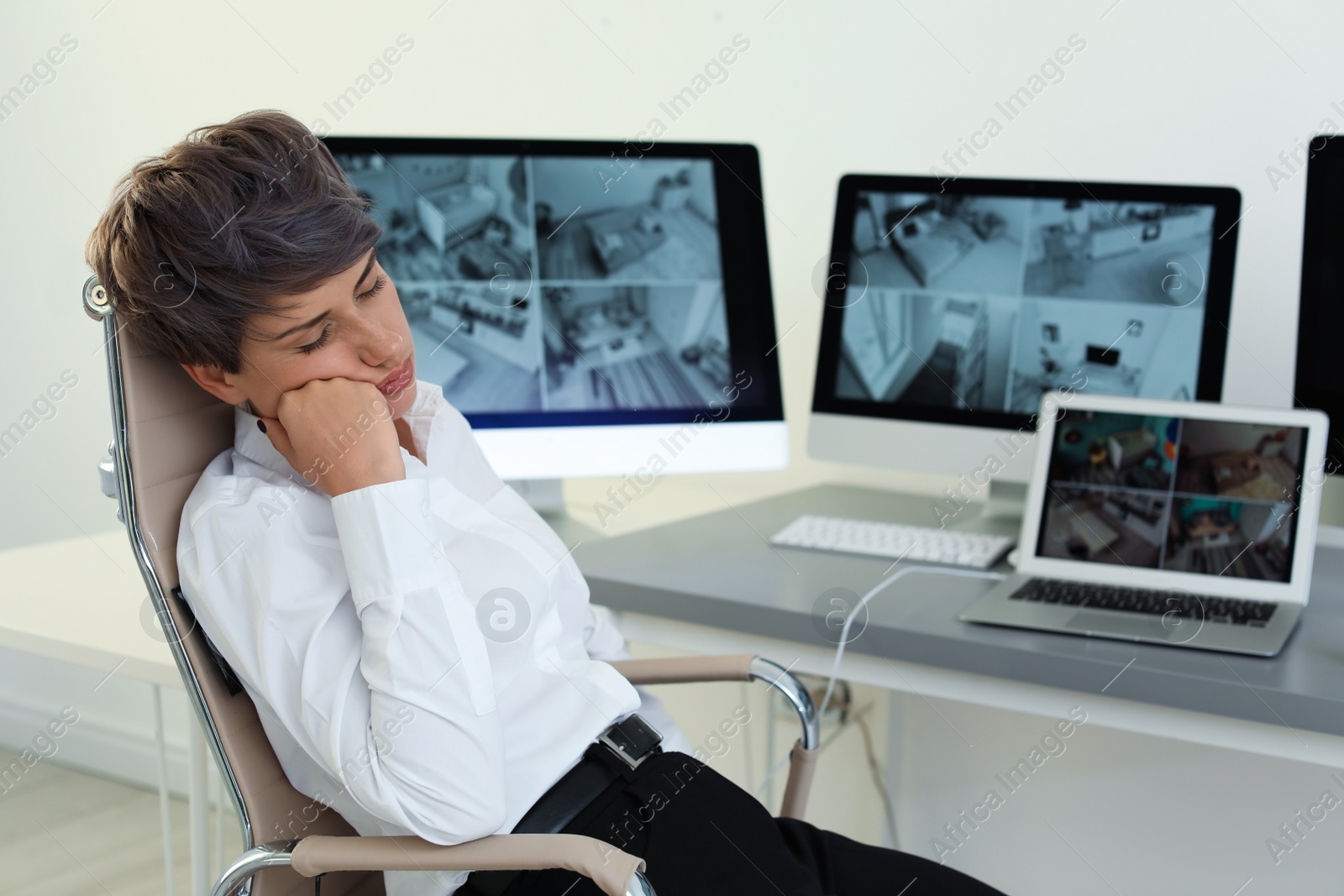 Photo of Female security guard sleeping at workplace indoors