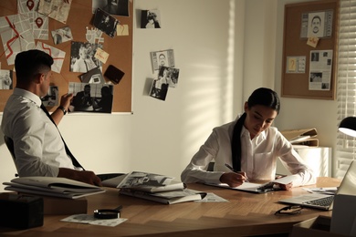 Professional detectives working at desk in office