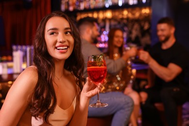 Photo of Friends spending time together in bar. Beautiful woman with fresh alcoholic cocktail, space for text