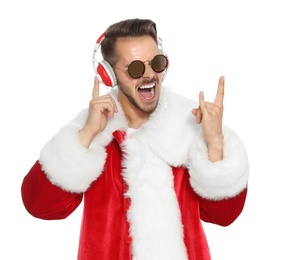 Photo of Young man in Santa costume listening to Christmas music on white background
