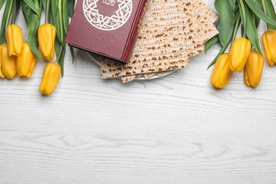 Photo of Flat lay composition with matzo and Torah on wooden background, space for text. Passover (Pesach) Seder
