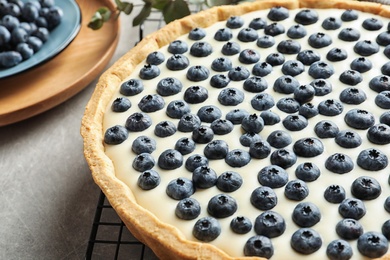 Photo of Tasty cake with blueberry on gray table