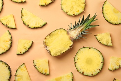 Photo of Flat lay composition with cut and fresh juicy pineapples on color background