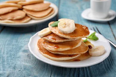 Photo of Tasty pancakes with honey and banana on table