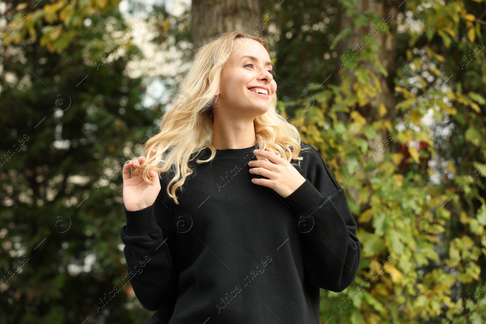 Photo of Happy woman in stylish warm sweater outdoors