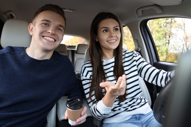 Photo of Happy young couple travelling together by car