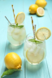 Photo of Natural lemonade with mint on light blue wooden table. Summer refreshing drink