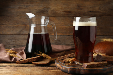 Composition with delicious kvass, spikes and bread on wooden table