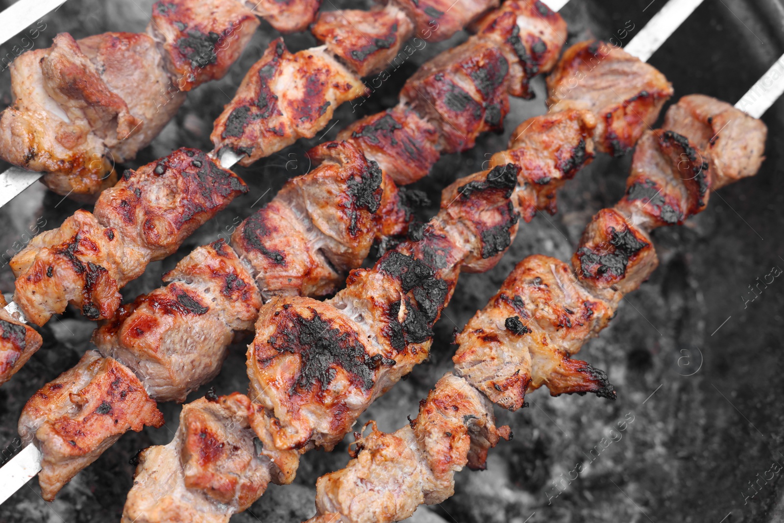 Photo of Cooking delicious kebab on metal brazier, above view