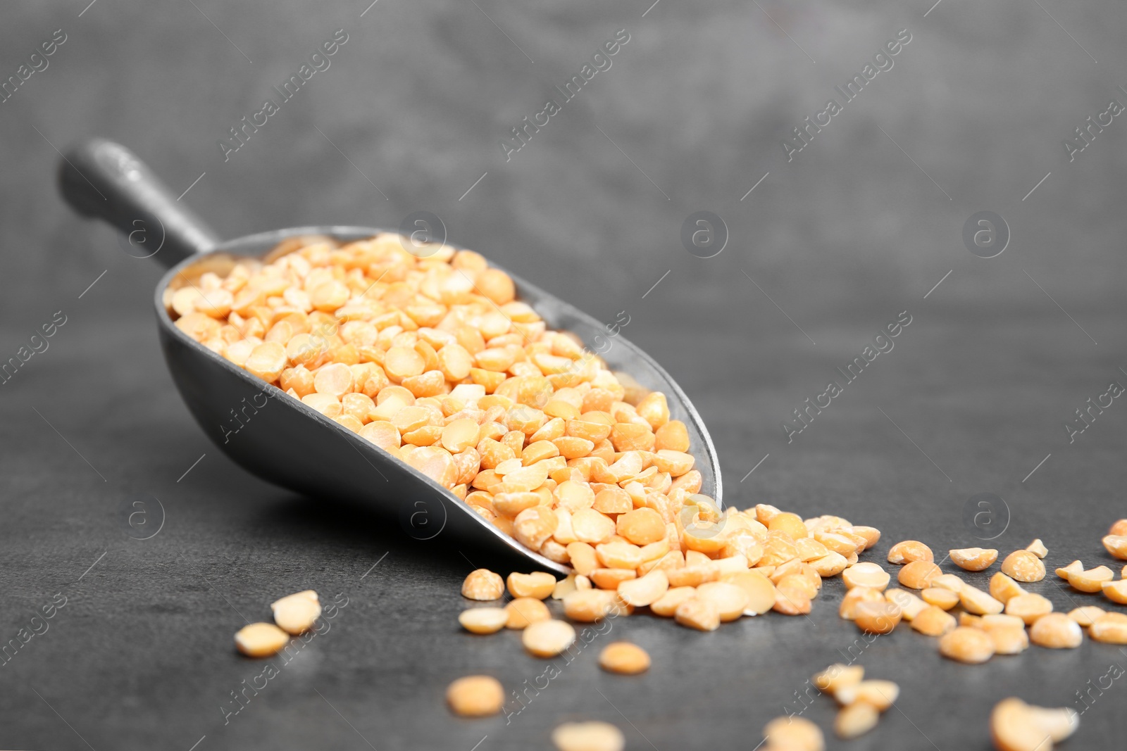 Photo of Metal scoop with dried peas on table