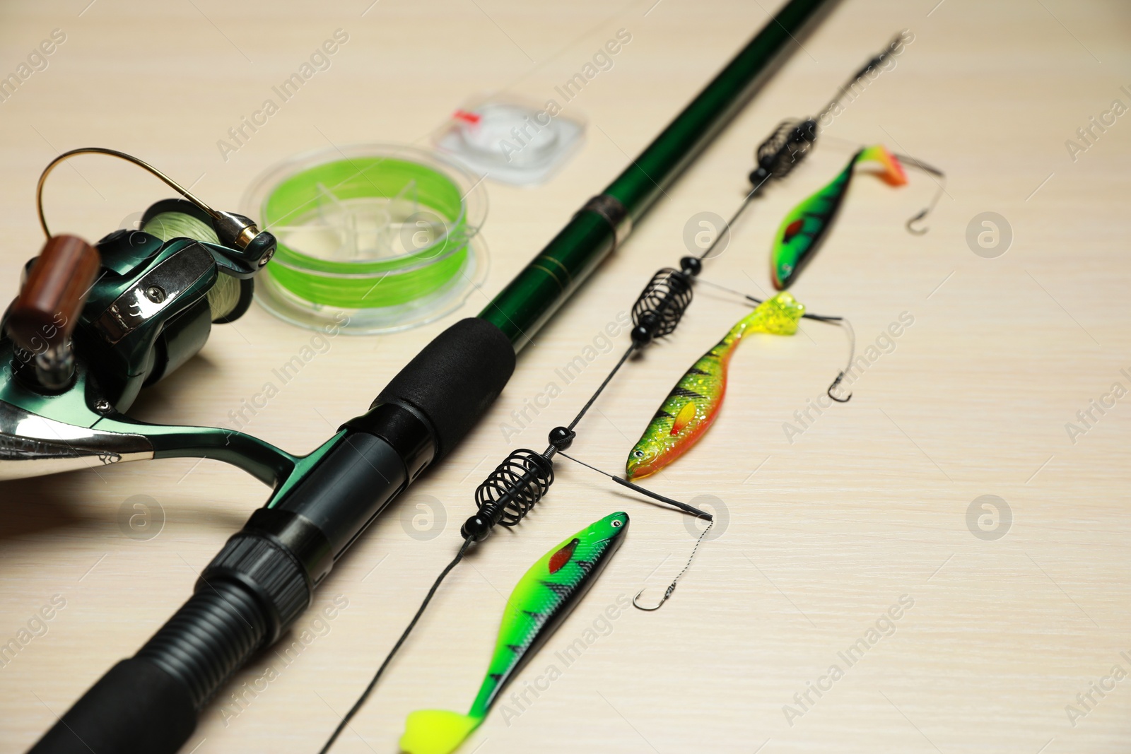 Photo of Fishing tackle on light wooden background, closeup