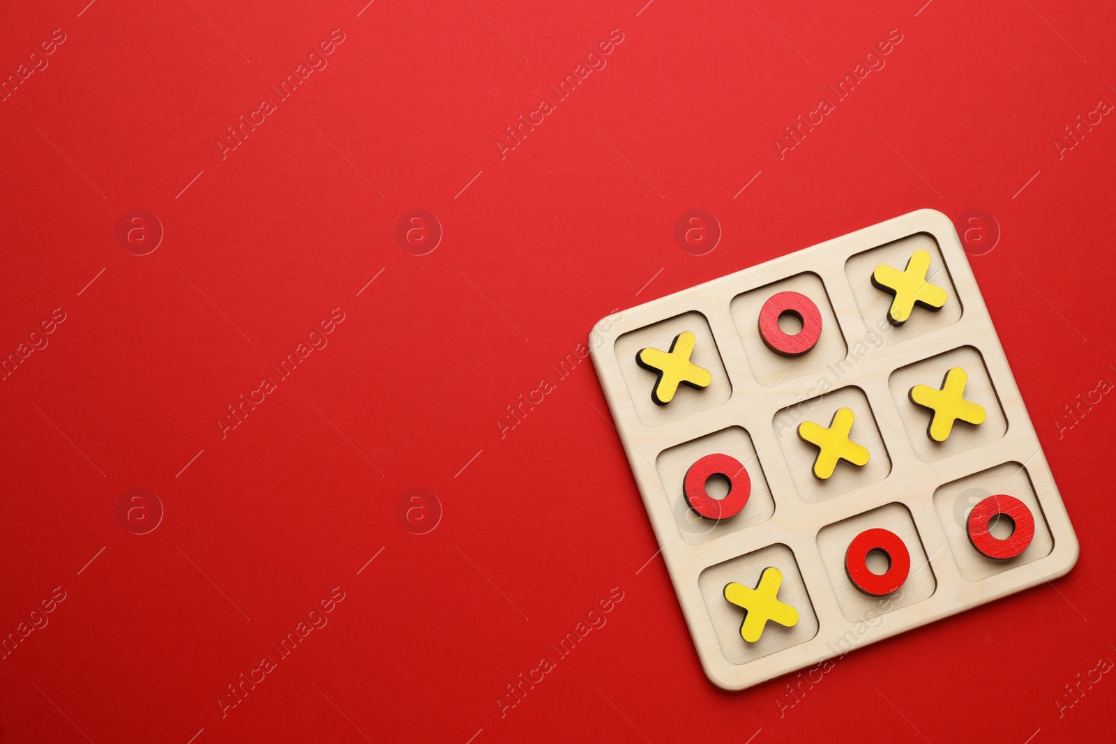 Photo of Tic tac toe set on red background, top view. Space for text