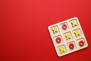 Photo of Tic tac toe set on red background, top view. Space for text