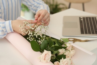 Photo of Woman making bouquet following online florist course at home, closeup. Space for text