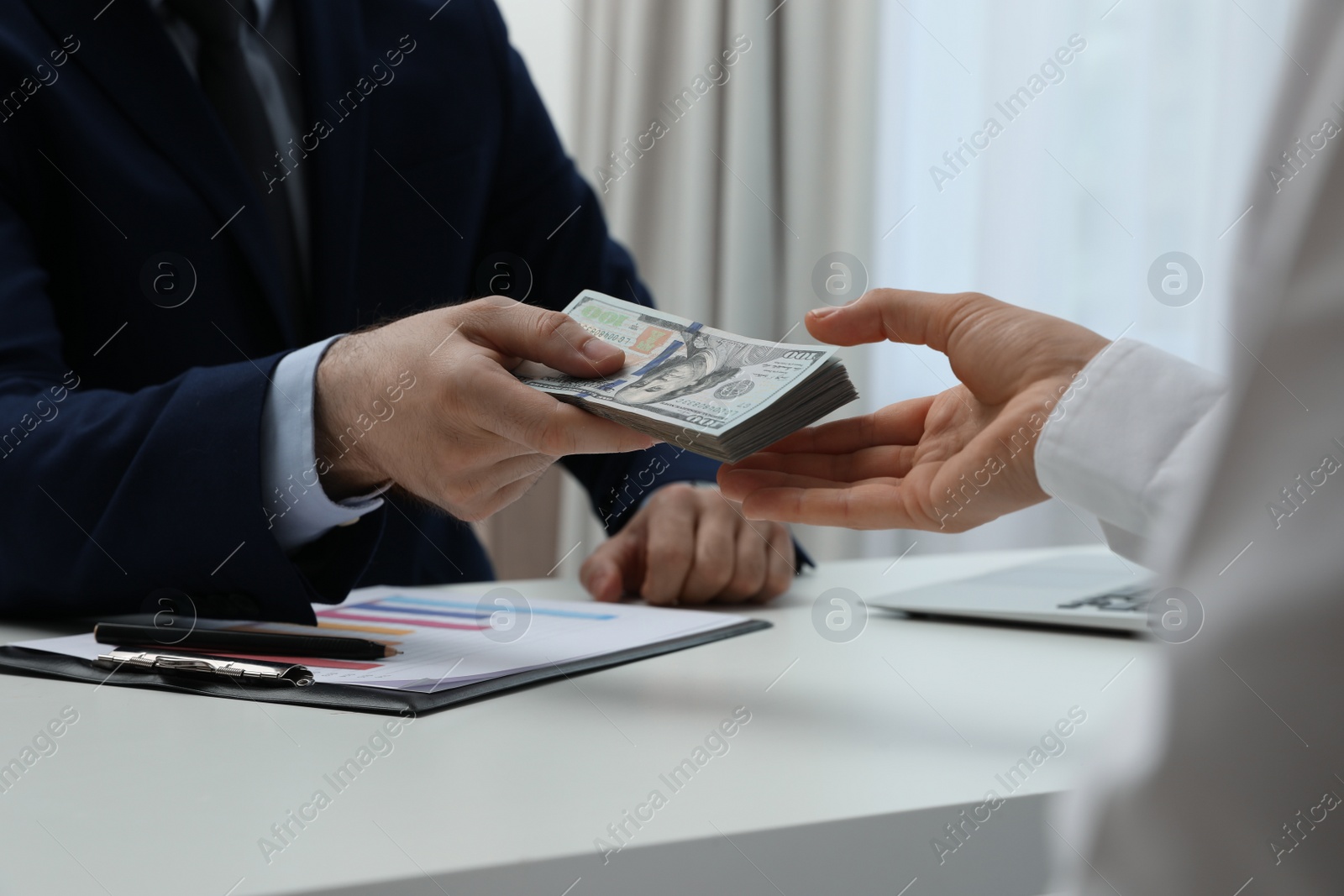 Photo of Cashier giving money to businesswoman at desk in bank, closeup