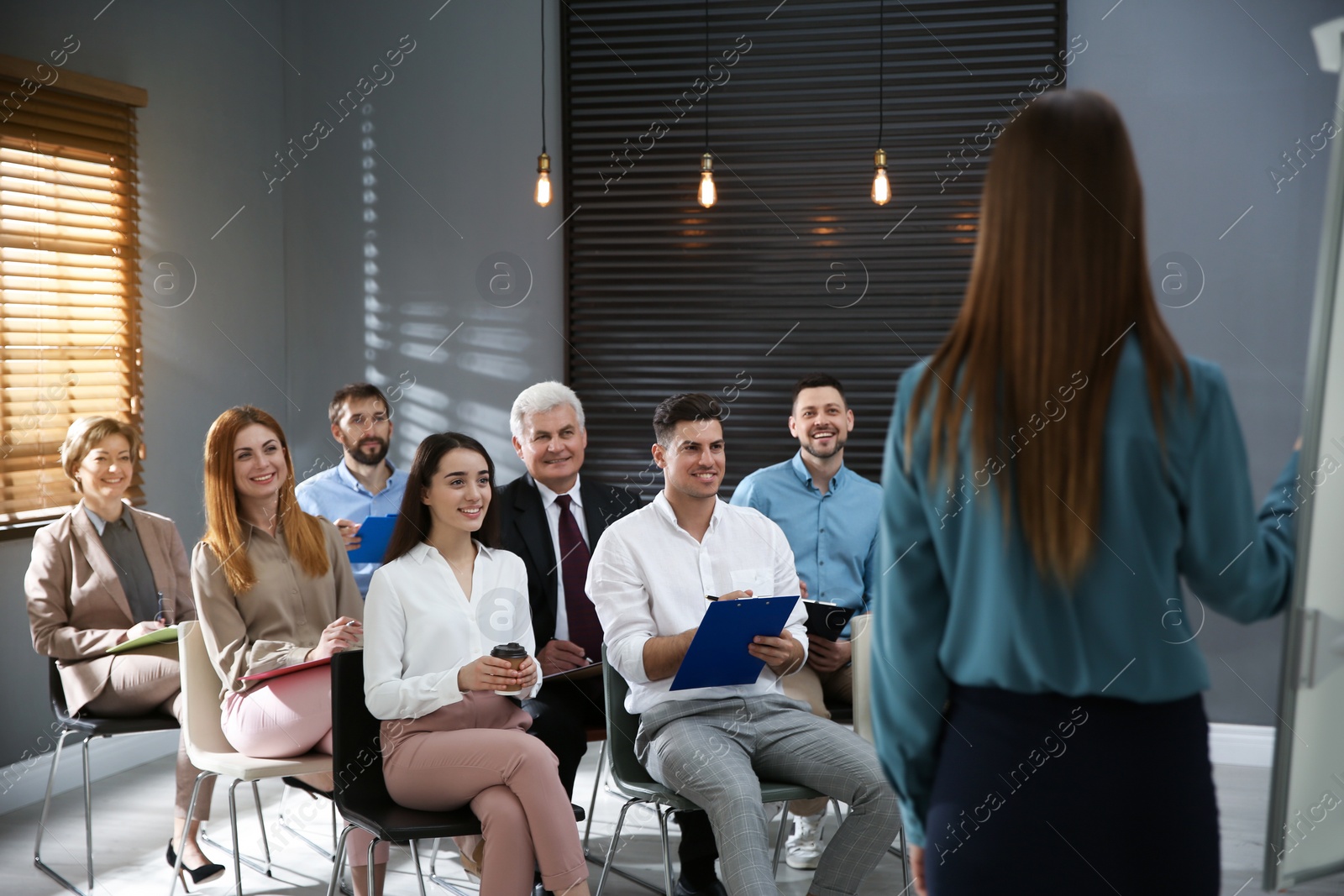 Photo of Business trainer answering questions at seminar in conference hall