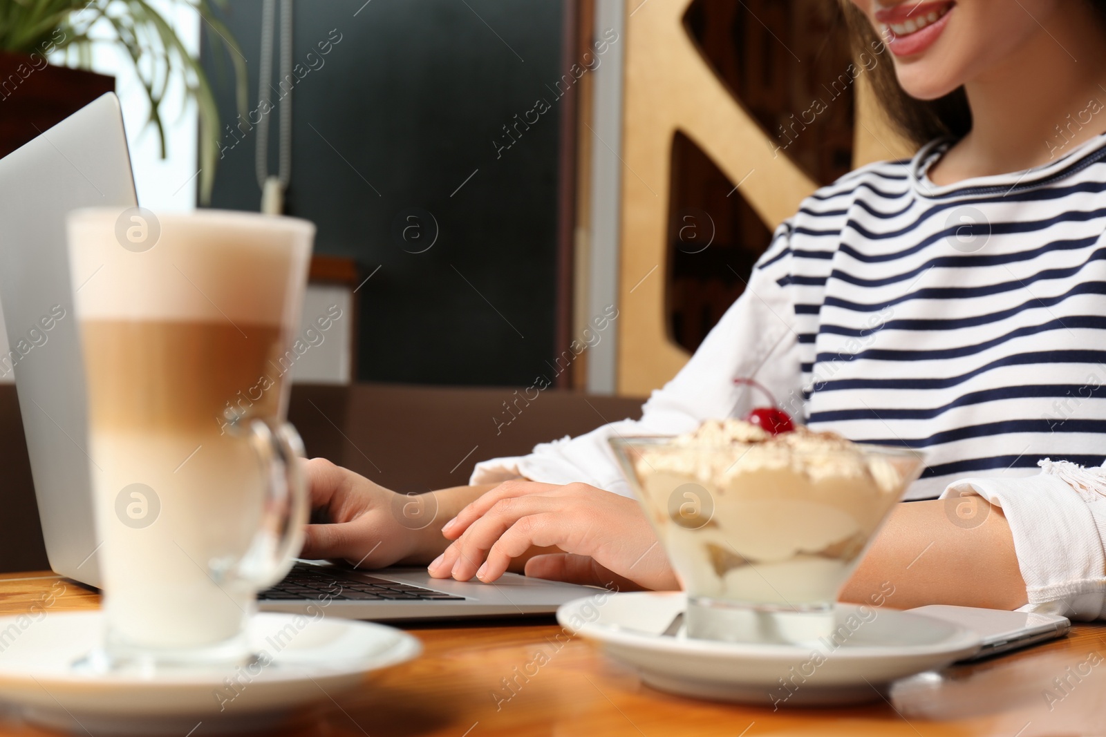 Photo of Blogger working with laptop in cafe, closeup