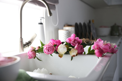 Photo of Bunch of beautiful peonies in kitchen sink