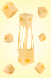 Pieces of cheese falling on yellow background