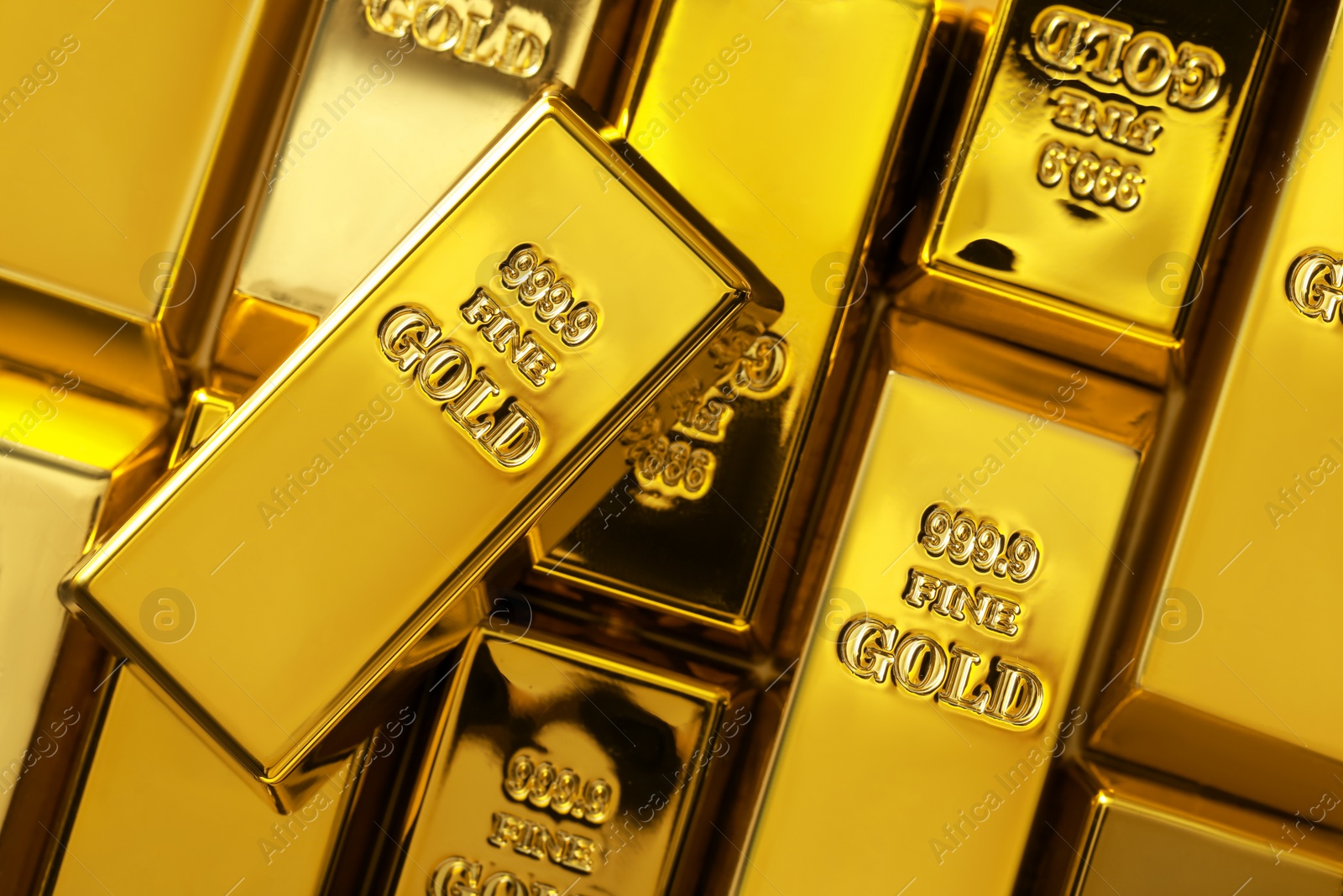 Photo of Many shiny gold bars as background, top view