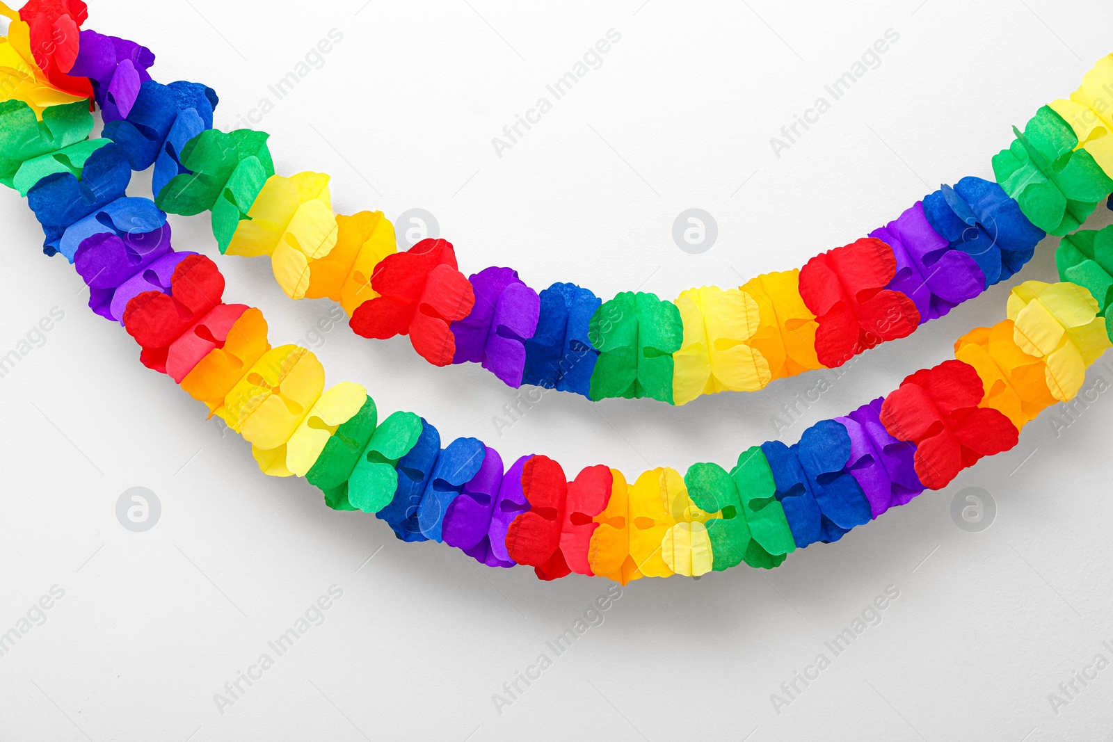 Photo of Rainbow paper garlands on beige background. LGBT pride