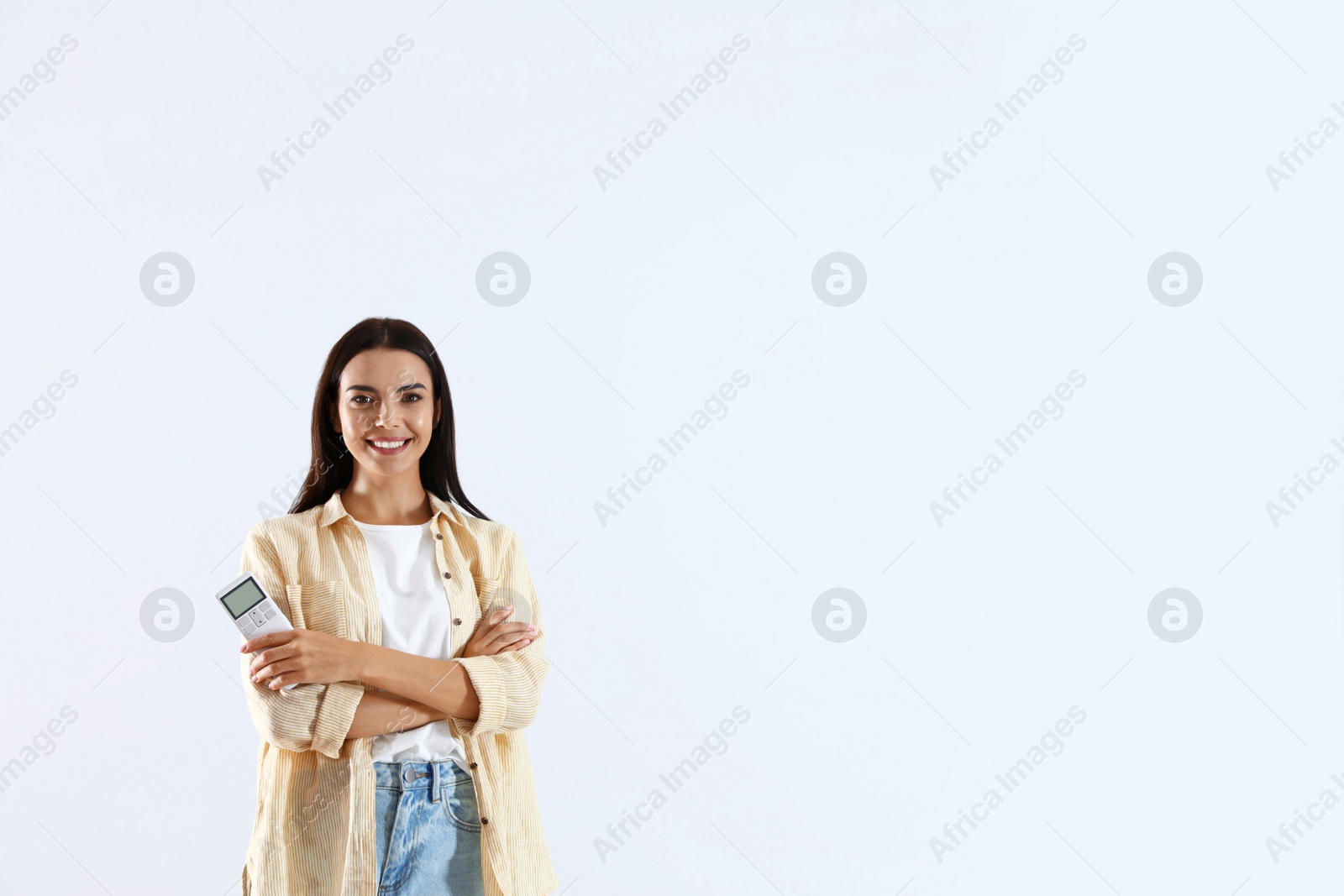 Photo of Young woman with air conditioner remote on white background