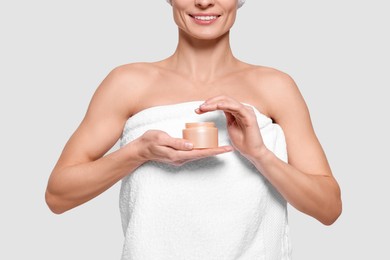 Photo of Woman with jar of body cream on white background, closeup