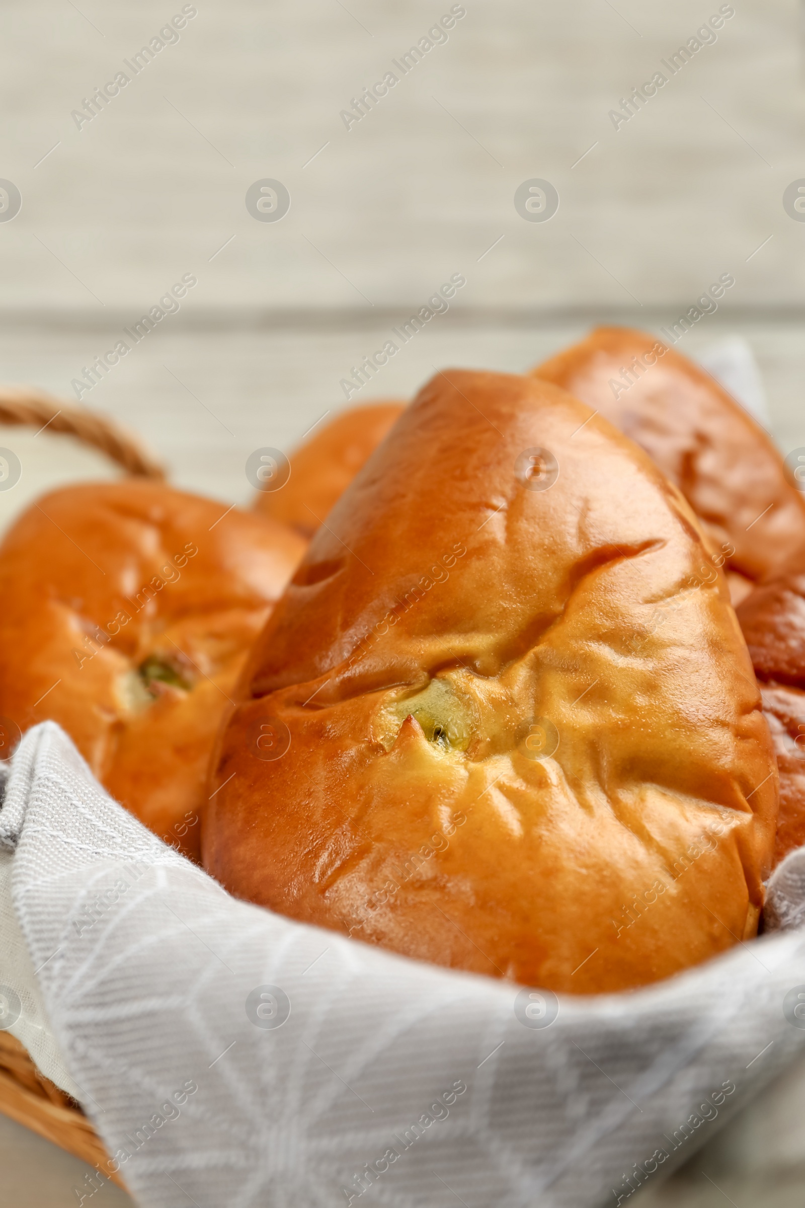 Photo of Basket with delicious baked patties, closeup view