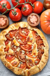 Photo of Tasty galette with tomato and cheese (Caprese galette) on parchment, top view