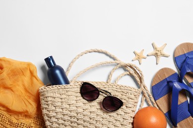 Photo of Flat lay composition with wicker bag and other beach accessories on white background. Space for text