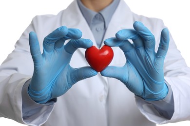 Doctor wearing light blue medical gloves holding decorative heart on white background, closeup