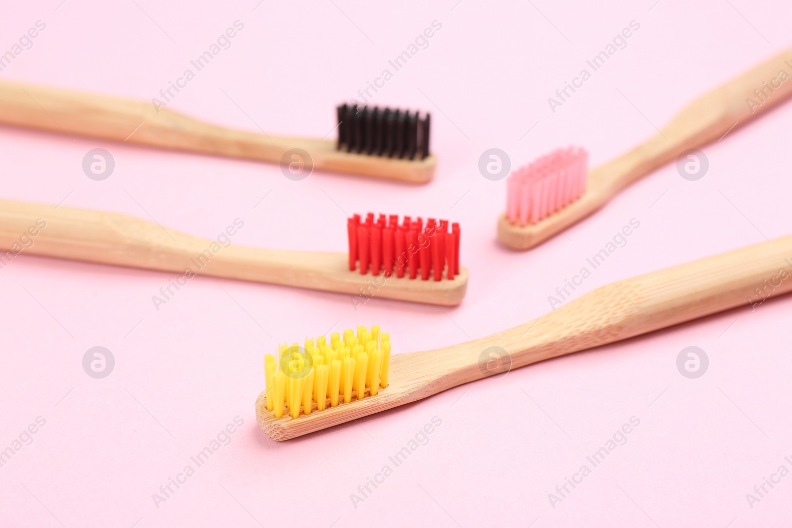 Photo of Toothbrushes made of bamboo on pink background