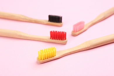 Toothbrushes made of bamboo on pink background