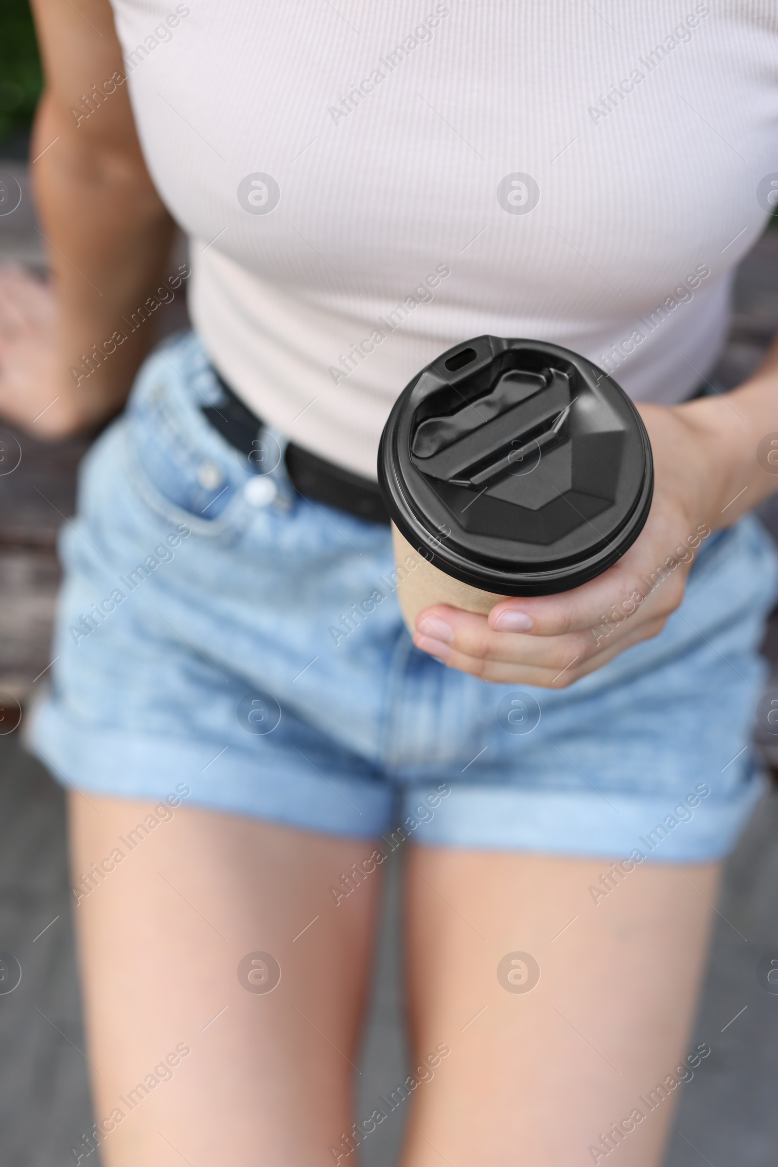 Photo of Coffee to go. Woman with paper cup of drink outdoors, closeup