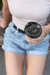 Photo of Coffee to go. Woman with paper cup of drink outdoors, closeup