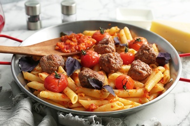 Pasta with meatballs and tomato sauce on table