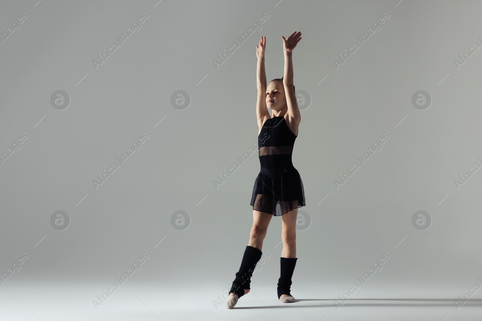 Photo of Cute little gymnast in stage clothes on white background