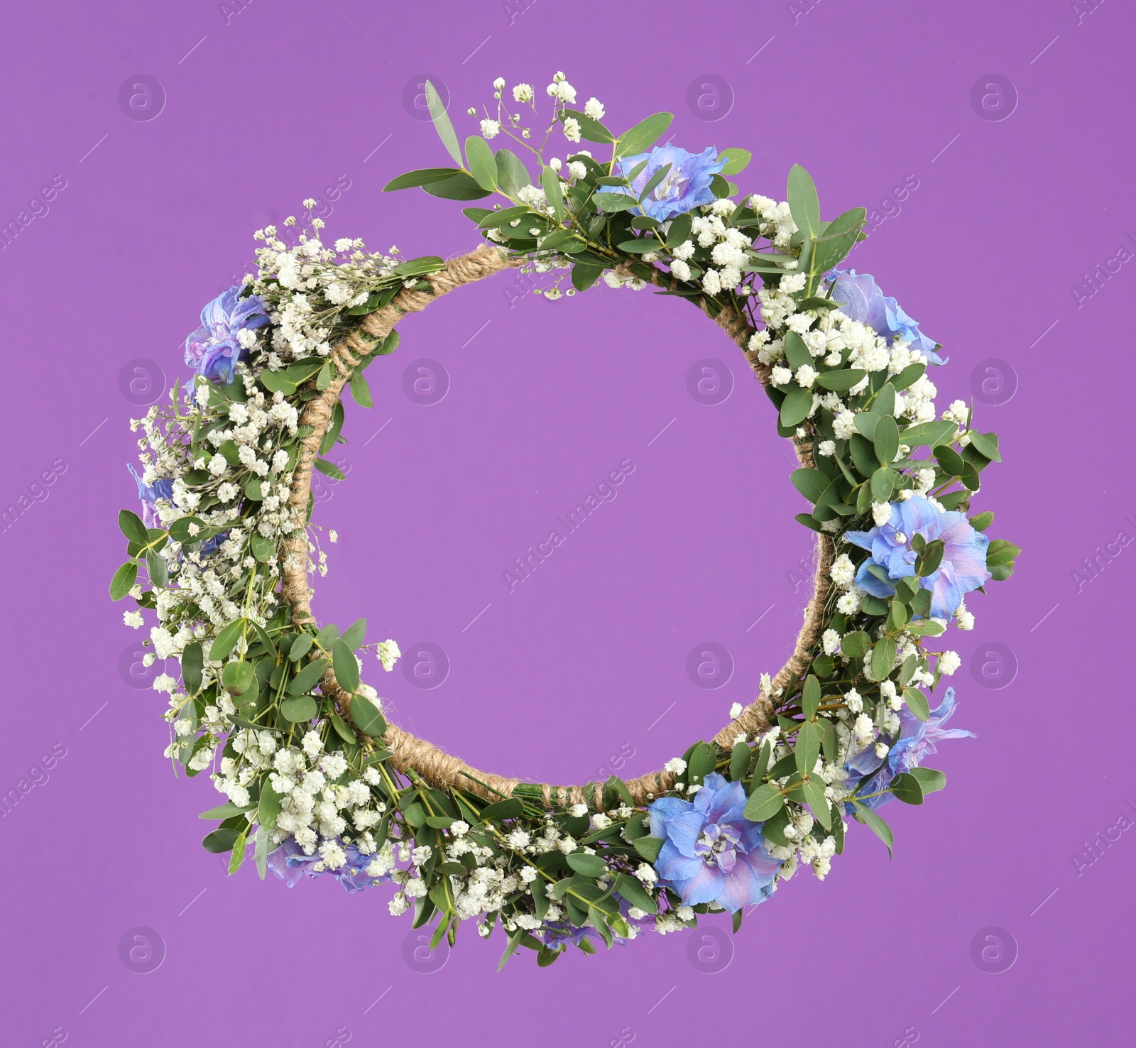 Photo of Beautiful handmade flower wreath on purple background