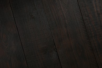 Photo of Texture of dark brown wooden surface as background, closeup