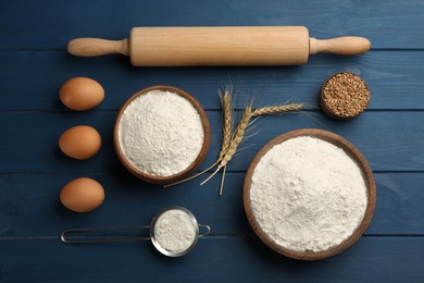 Flat lay composition with flour and eggs on blue wooden table