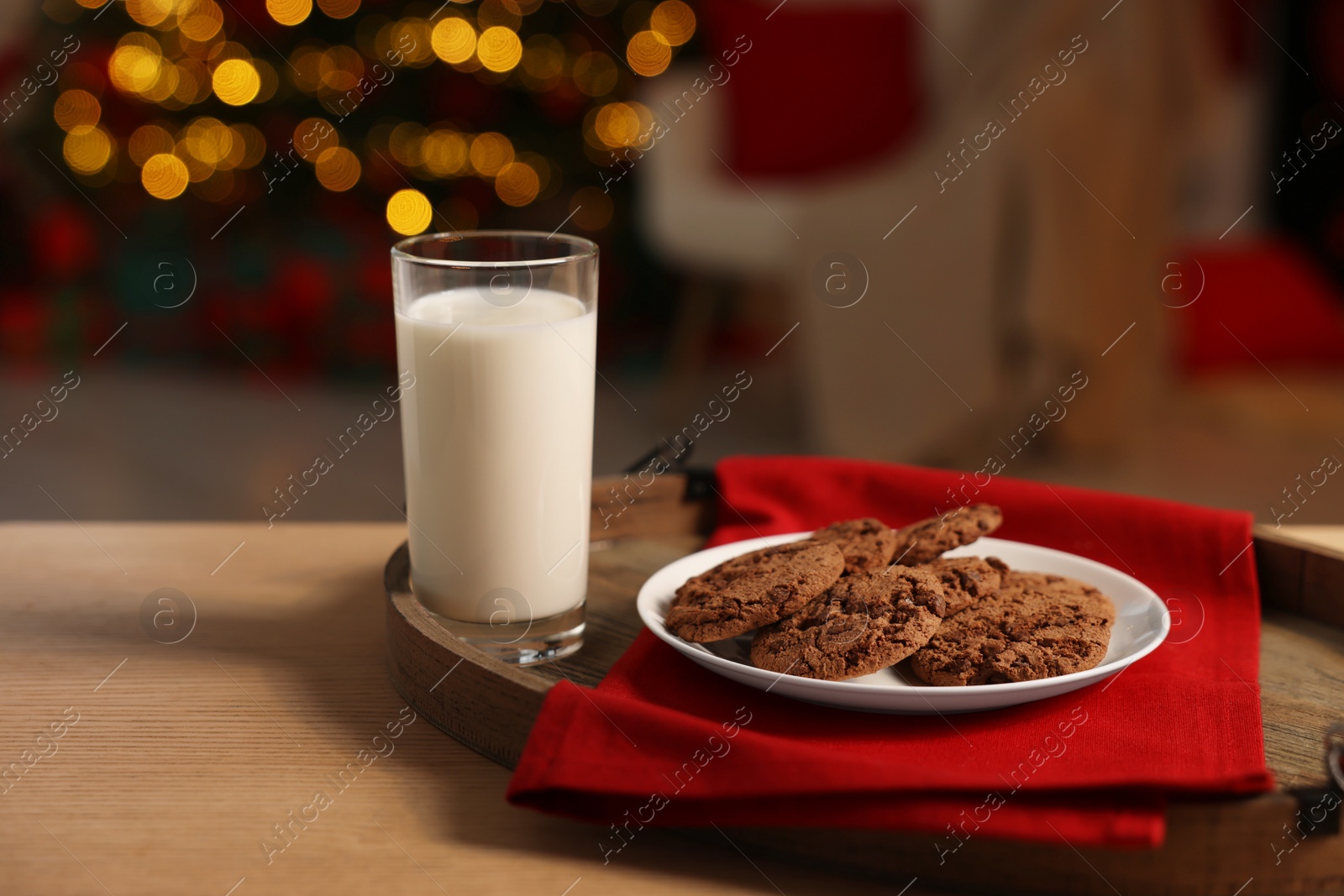 Photo of Merry Christmas. Milk and cookies for Santa on table in room, space for text