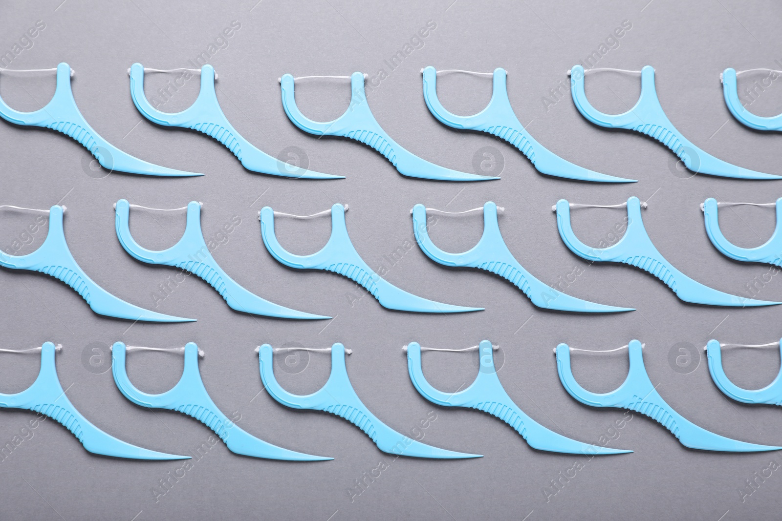 Photo of Flat lay composition with dental floss picks on grey background