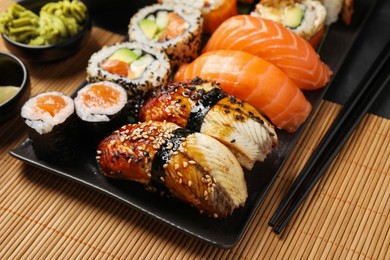 Set of delicious sushi rolls on mat, closeup